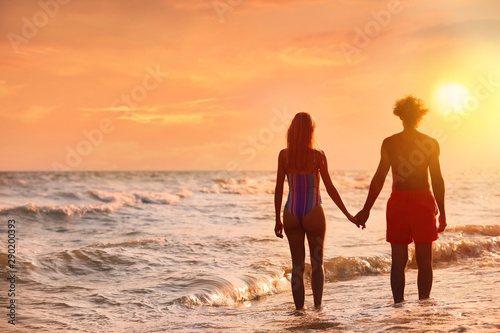 Wallpaper Mural Young woman in bikini and her boyfriend on beach at sunset. Lovely couple Torontodigital.ca