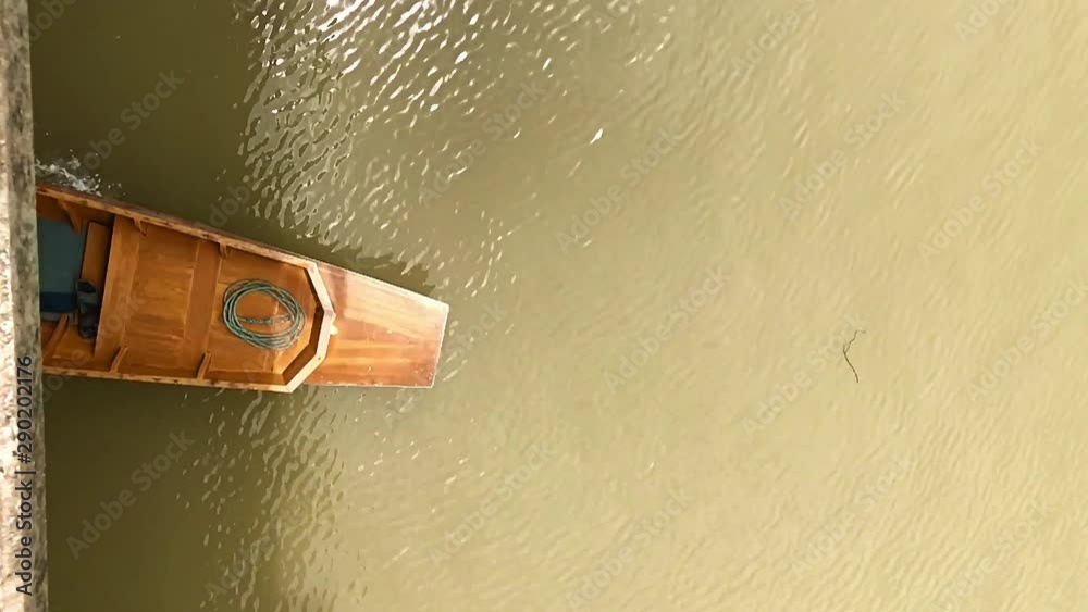 The traditional boat - long tail with long rod of engine on river under bridge, top view. Water transport in Thailand, slow motion. Version with sound.