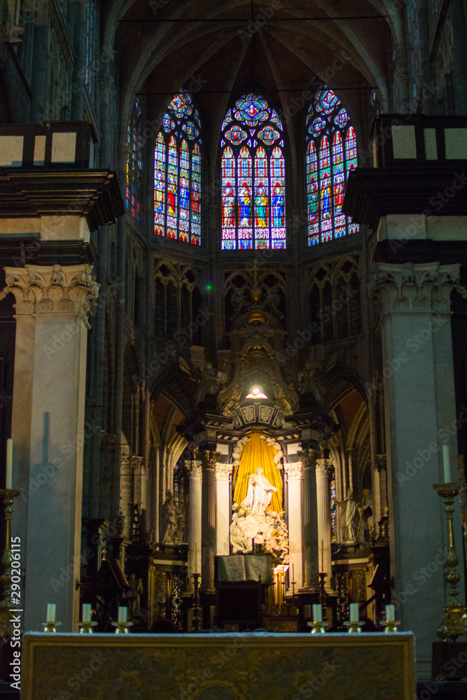 Colorful stained glass window and altar inside of the Saint Bavo Cathedral (or Sint-Baafs Cathedral) in Ghent, Belgium, Europe