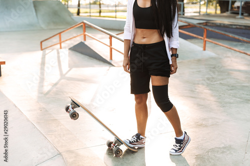 Cropped image of a girl teenager standing with longboard