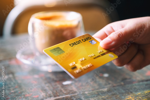 Closeup image of a hand holding and giving credit card