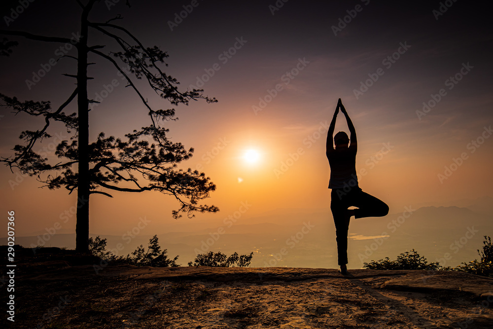 Young girl practicing  yoga  on the high mountain in Phu-kra-dueng national park Loei province, Thailand.