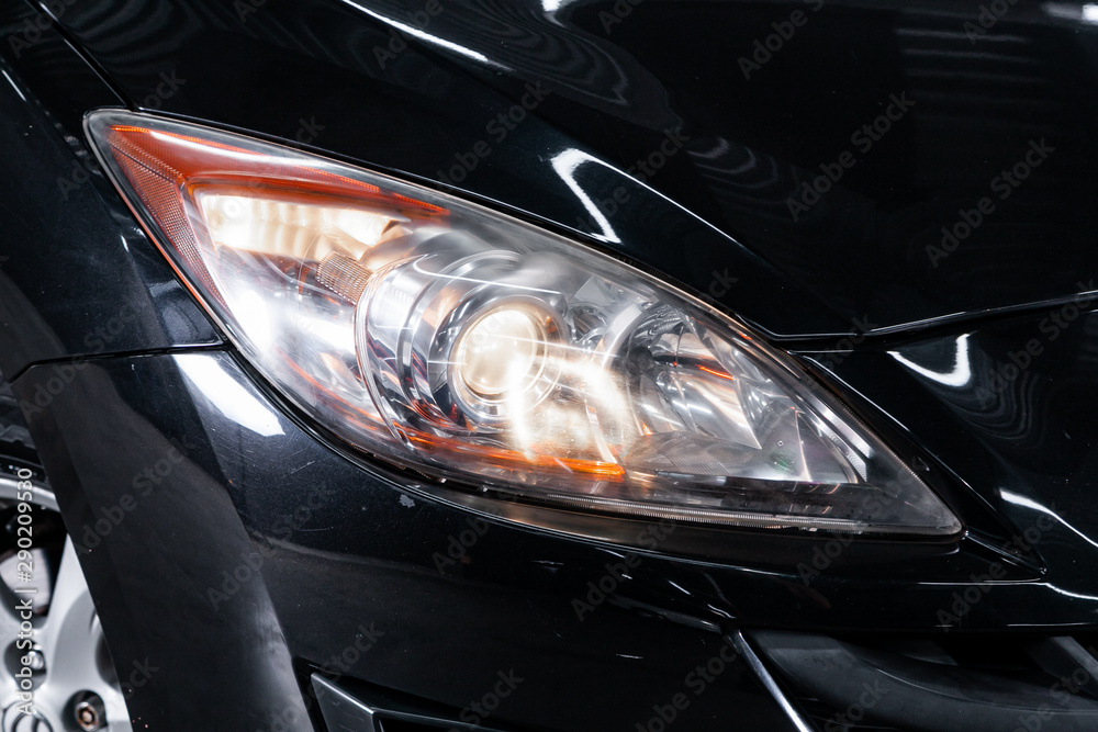 Black car headlights. Exterior detail. Close up detail on one of the LED headlights modern car..