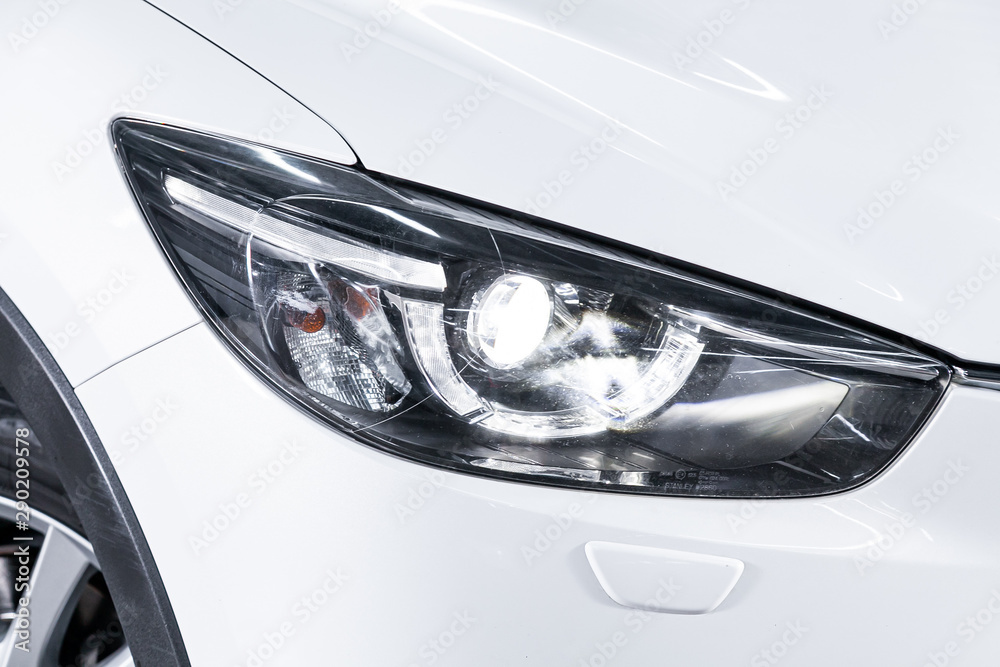 White car headlights. Exterior detail. Close up detail on one of the LED headlights modern car..