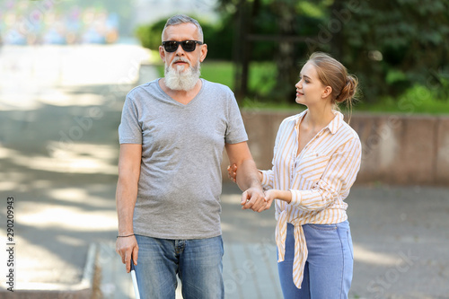 Woman helping blind mature ...