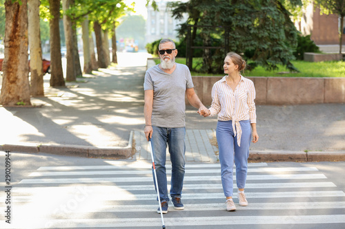 Woman helping blind mature ...