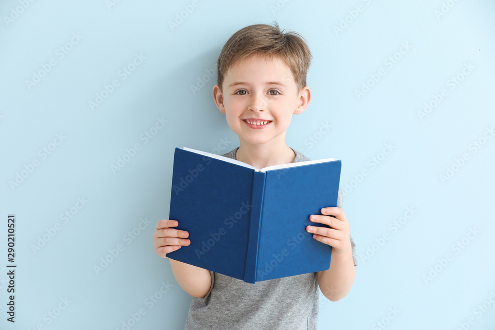 Little boy reading book on color background - obrazy, fototapety, plakaty 