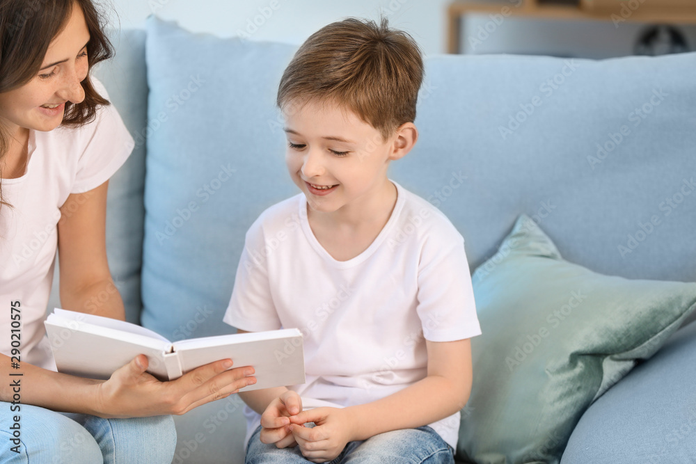 Little boy and his elder sister reading book at home Little boy and his elder sister reading book at home