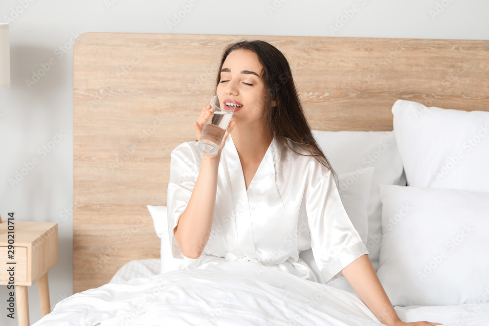 Morning of beautiful young woman drinking water in bedroom Morning of beautiful young woman drinking water in bedroom