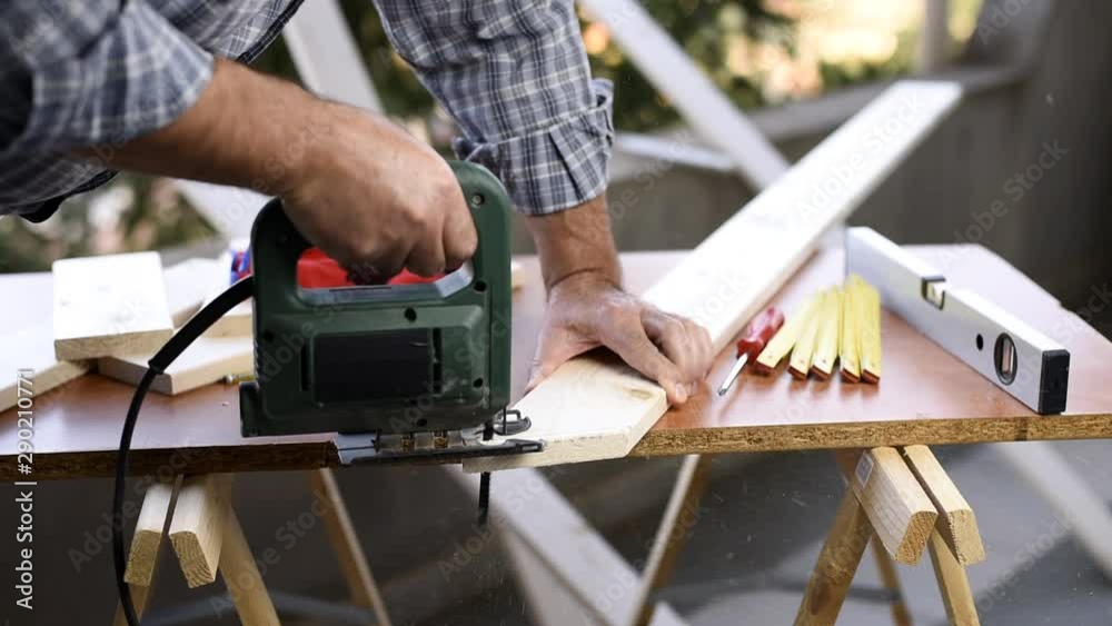 Adult craftsman carpenter with electric saw working on cutting a wooden table. Housework, do it yourself. Footage. Adult craftsman carpenter with electric saw working on cutting a wooden table. Housework, do it yourself. Footage.
