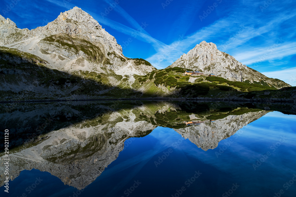 Obraz premium Morning sunrise at lake Drachensee in the alps, austria near Reutte, ehrwald. View of the Coburger Hütte and mountain vorderer Drachenkopf
