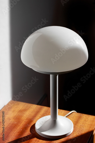 modern desk lamp with mushroom shape spaceage  vintage midcentury design front side view white black background with warm orange light isolated in the studio living room creative HIGH RESOLUTION  photo