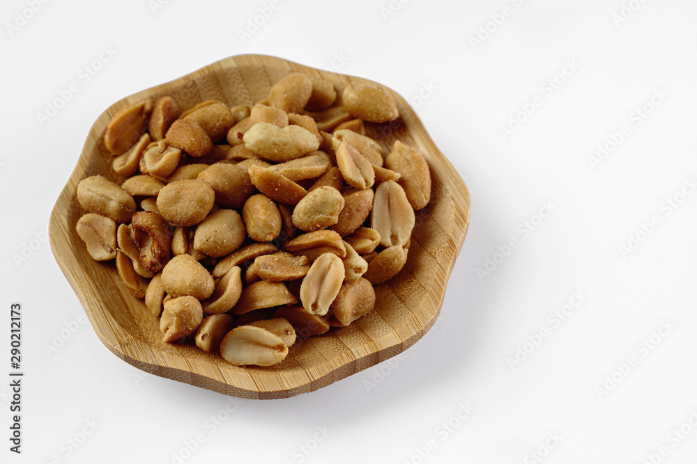 wood plate of salted peanuts isolated on white background. snack to beer wood plate of salted peanuts isolated on white background. snack to beer