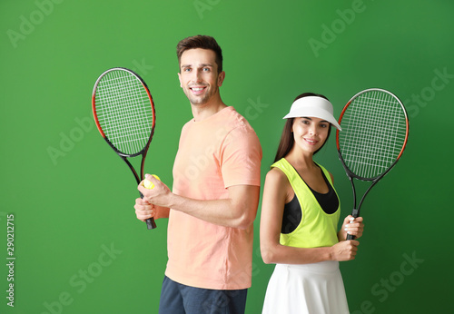 Young couple with tennis rackets on color background © Pixel-Shot