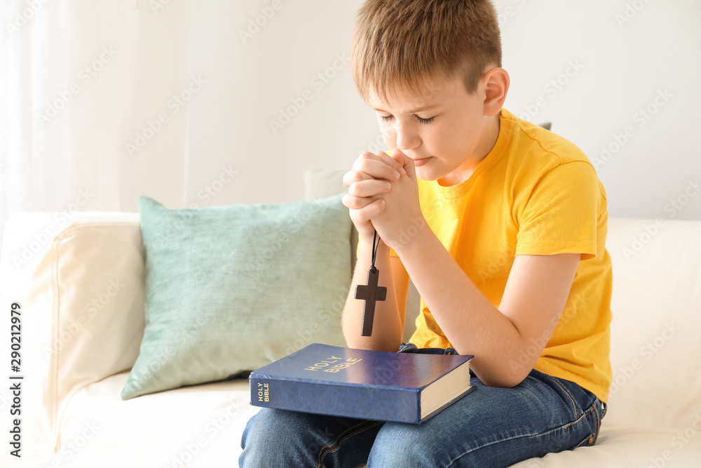 Cute little boy praying at home