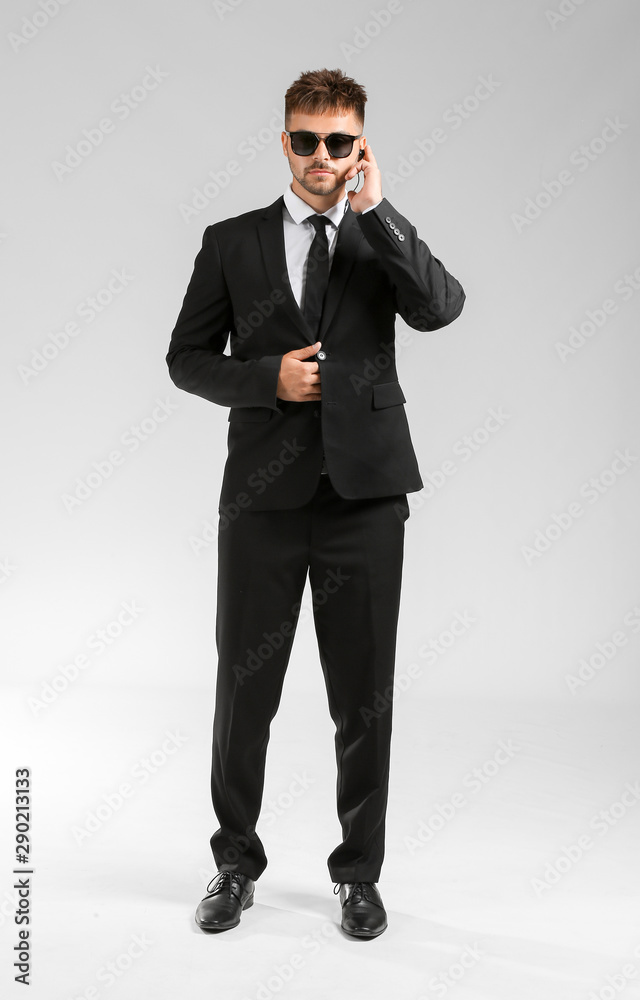 Handsome security guard on light background