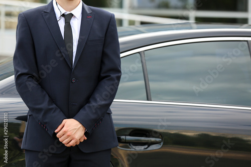 Professional bodyguard near car outdoors