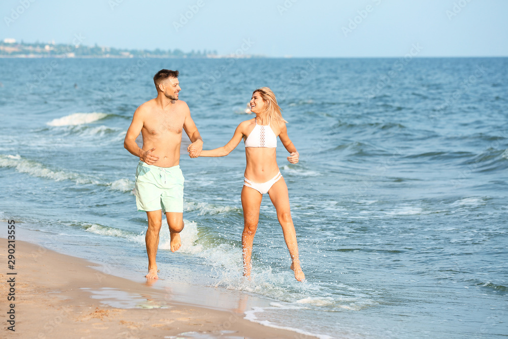 Happy couple running on sea beach