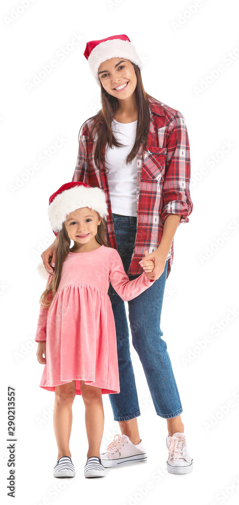 Fototapeta premium Woman and her little daughter in Santa hats on white background