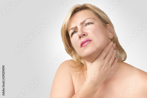 Sore throat. The woman suffers from painful swallowing  severe pain in the throat  touching the neck with her hand in the area of the disease. Women s health concept