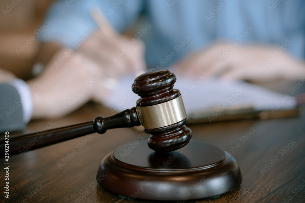 Judge gavel on wooden teable background with businessman and female lawyers having a meeting at a law firm. Concepts of law. Judge gavel on wooden teable background with businessman and female lawyers having a meeting at a law firm. Concepts of law.