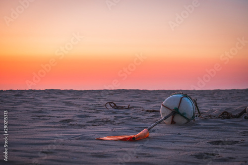 Boia de pescador na areia da praia ao por do sol