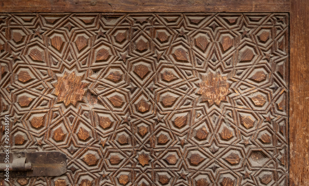 Geometrical engraved decorations of an aged wooden ornate door leaf, Old Cairo, Egypt