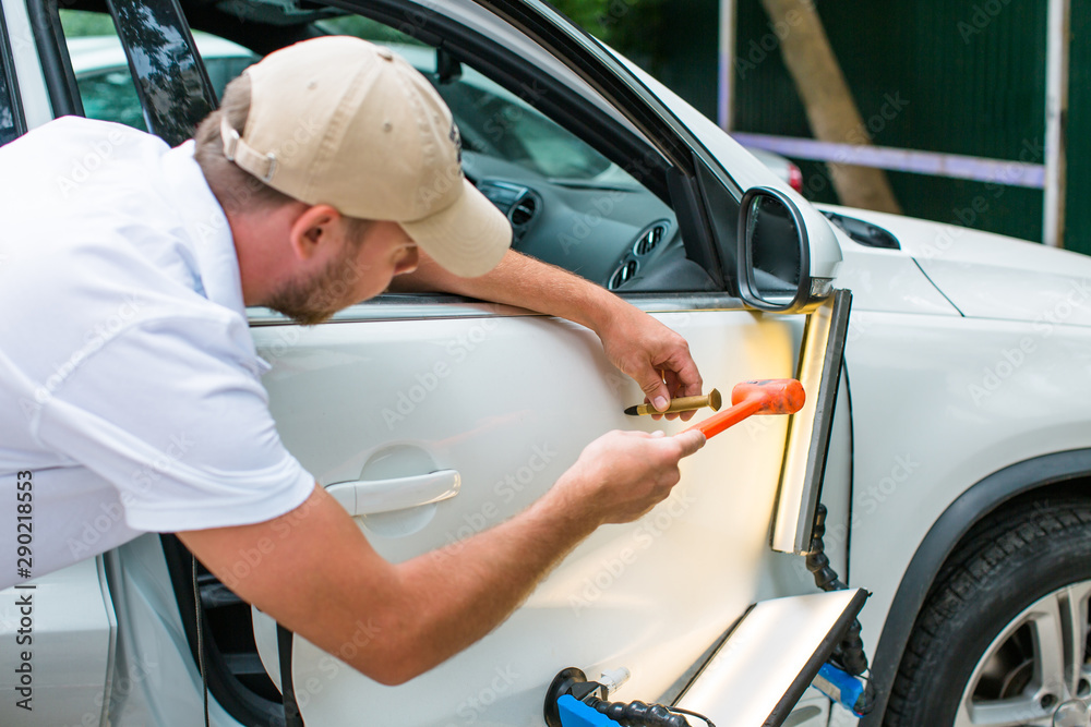 Repairing car dent after the accident by paintless dent repair I Stock  Photo