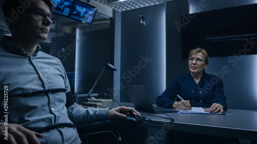 Female Special Agent Conducts Lie Detector / Polygraph Test on a Young Suspect. Expert Examiner Questions Accused in Interrogation Room. Computer Measures Physiological indices.