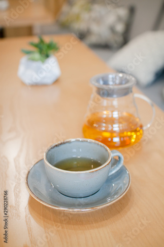herbal tea in a transparent glass teapot in the interior of a modern Scandinavian cafe