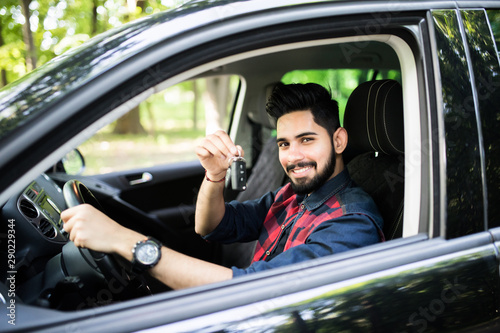 Happy indian man showing the key of his new car photo