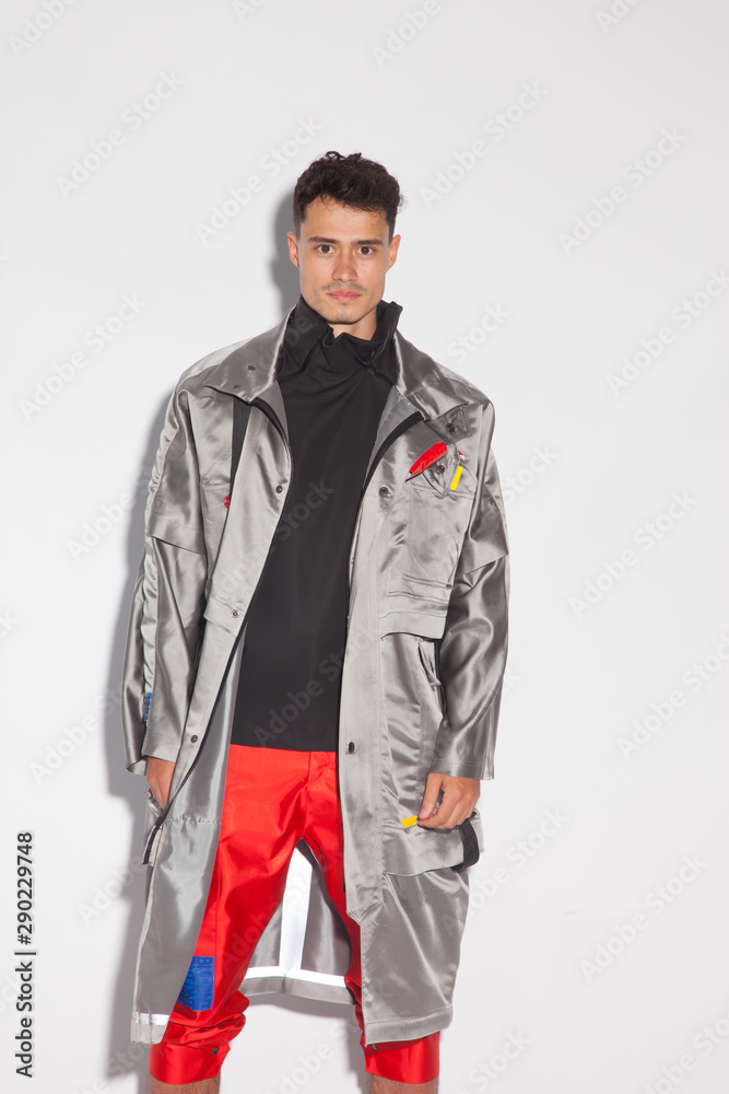 Chico joven con vestido de diseño sobre fondo blanco Chico joven con vestido de diseño sobre fondo blanco