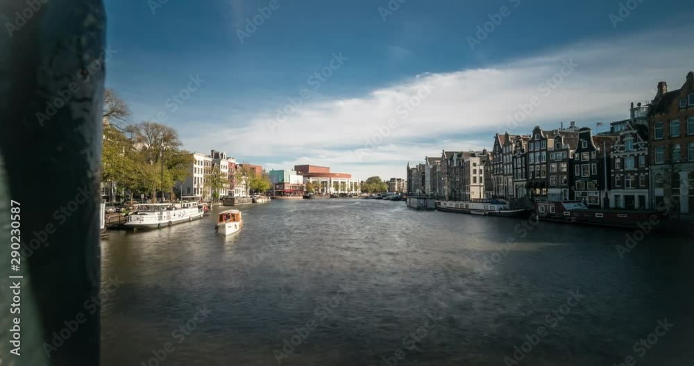 Timelapse video of boat traffic on the Amstel river running through Amsterdam. In the distance, the City Hall, National Opera and Theater can be seen. Timelapse video of boat traffic on the Amstel river running through Amsterdam. In the distance, the City Hall, National Opera and Theater can be seen.
