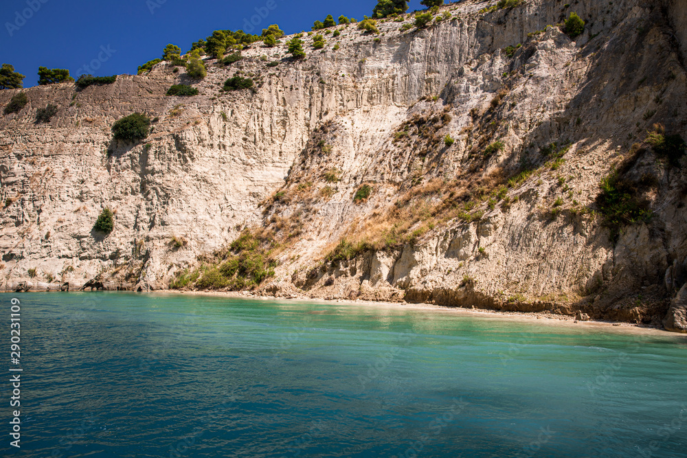 Turquoise water and rock walls of the Corinth Canal, Greece. The Corinth Canal connects the Gulf of Corinth with the Saronic Gulf in the Aegean Sea.