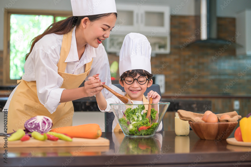 Happy beautiful Asian woman and cute little boy with eyeglasses prepare to cooking in kitchen at home. People lifestyles and Family. Homemade food and ingredients concept. Two Thai people life Happy beautiful Asian woman and cute little boy with eyeglasses prepare to cooking in kitchen at home. People lifestyles and Family. Homemade food and ingredients concept. Two Thai people life