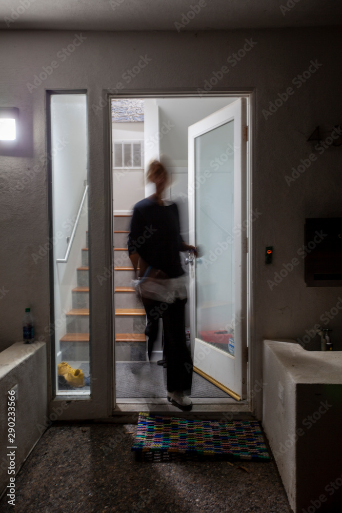 Blurry woman walking through door
