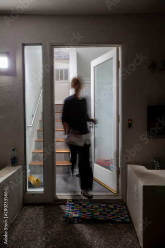 Blurry woman walking through door