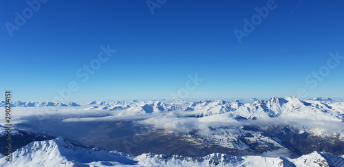 Panoramic view above clouds in valley of snowy mountain in european Alps
