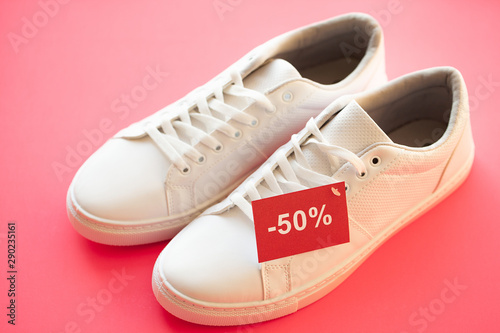 Stylish white fashion sneakers on pink background.