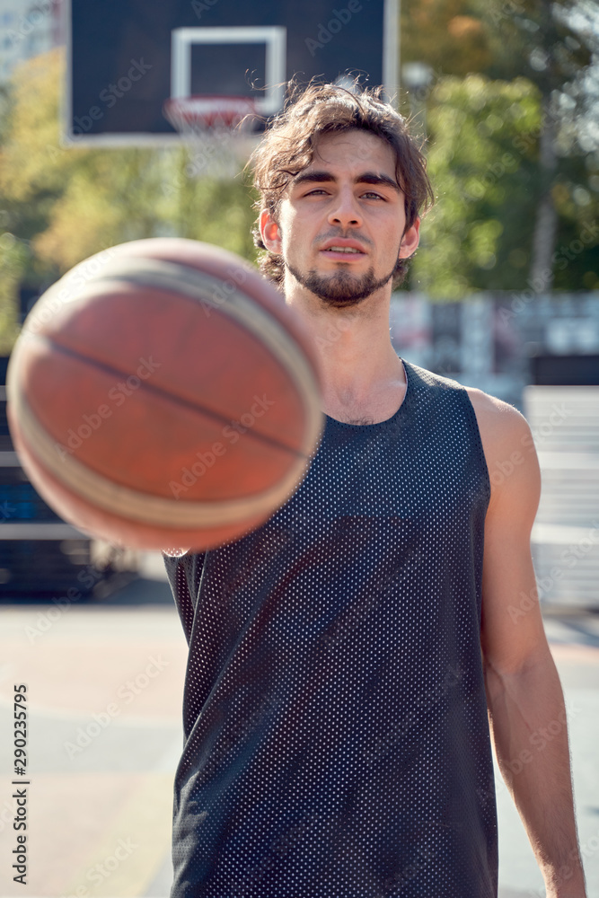 Photo of athlete man in blue T-shirt with ball in his hands on sports field