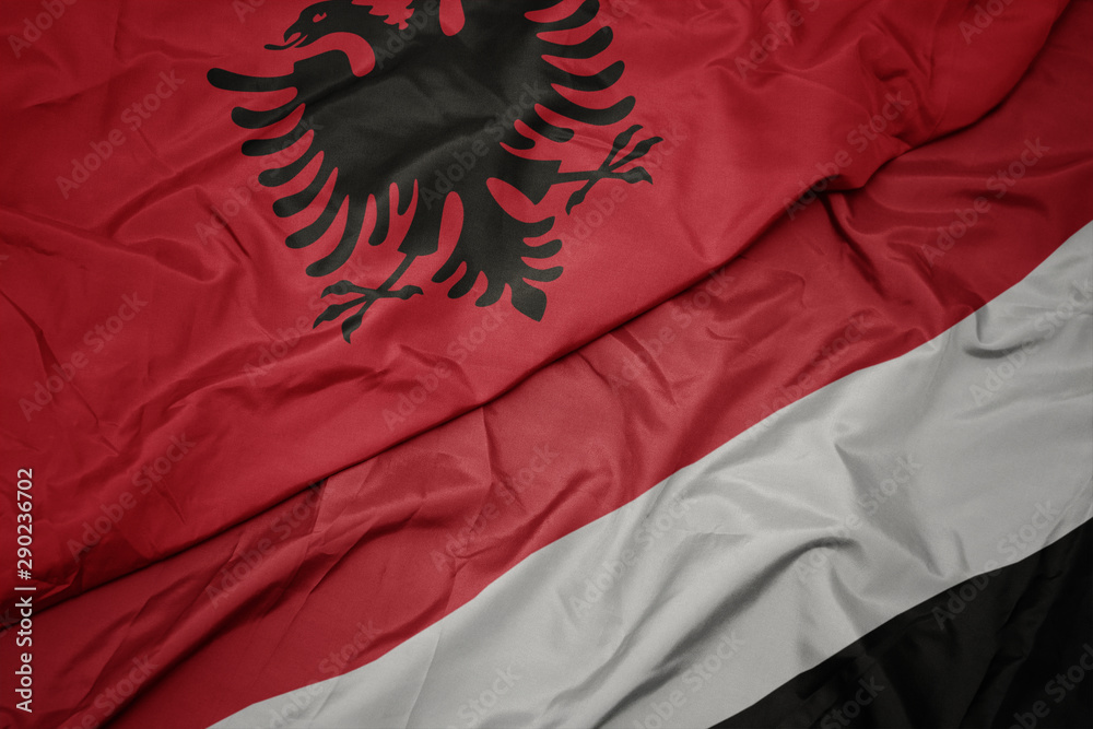 waving colorful flag of yemen and national flag of albania. waving colorful flag of yemen and national flag of albania.