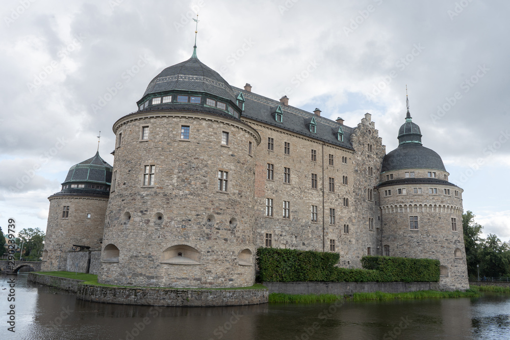 Orebro castle with clouds. Castle view from pond side. Travel photo, background or illustration.