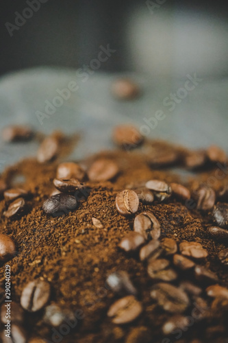 Coffee beans with ground coffee heap. Arabic roasted coffee on rock, Marble plate and dark background.
