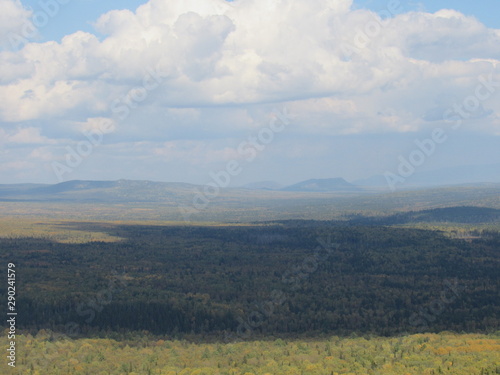 Ural mountains under cloudy Sunny sky in warm autumn.