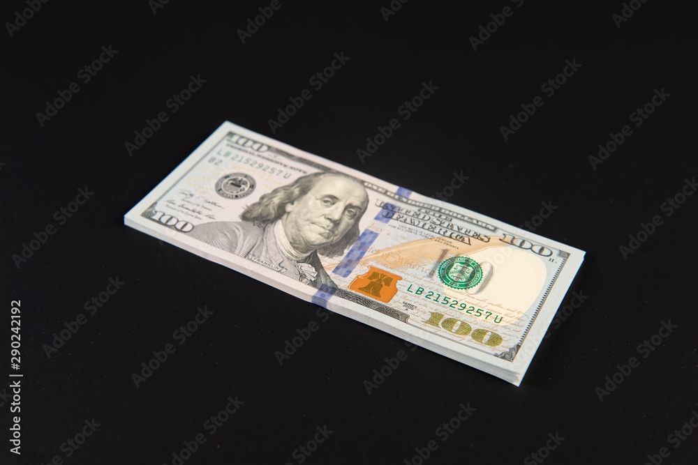 Bundle of one hundred dollar bills on a black background Bundle of one hundred dollar bills on a black background