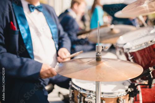 Close-up of a drum cymbal drummer knocking on it with chopsticks - selective focus