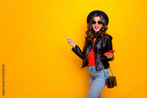 Portrait of excited shocked surprised girl with wavy hairstyle follow comment promo discount scream wow omg wear black leather jacket isolated over yellow color background