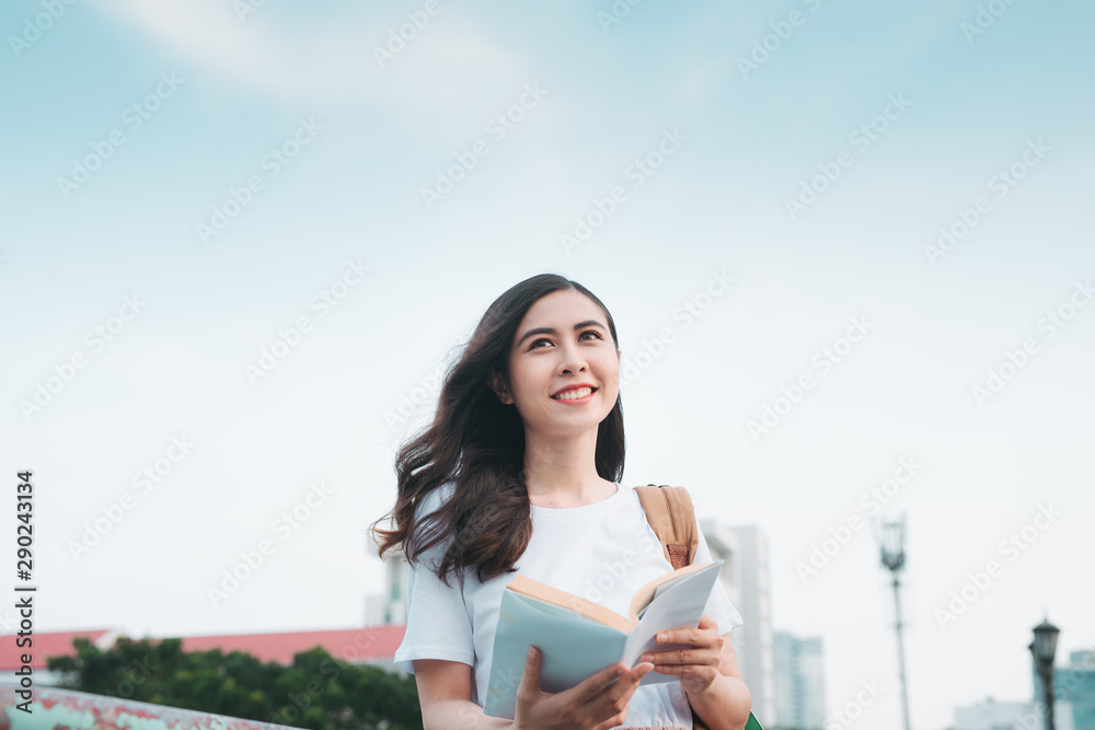 Asian Business Woman traveling, standing by railing bridge, reading book on city background. Asian Business Woman traveling, standing by railing bridge, reading book on city background.
