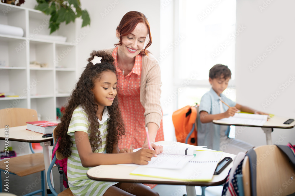 Beaming teacher feeling good while doing her favorite job Beaming teacher feeling good while doing her favorite job