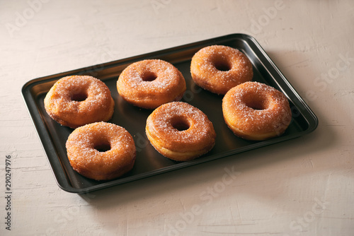 Donuts with sugar on a tray in a bar